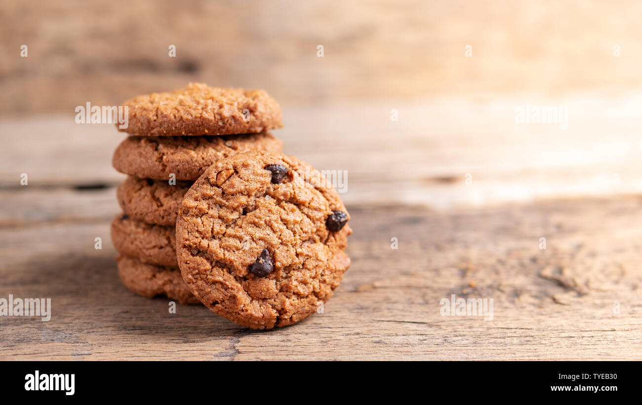 Pila di biscotti con scaglie di cioccolato su un tavolo di legno Foto Stock