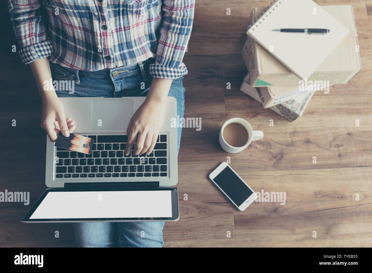 Vista superiore della donna shopping online con carta di credito tramite computer portatile da casa sul pavimento in legno con molti scatola per il confezionamento di pacchi postali. shopping online Foto Stock