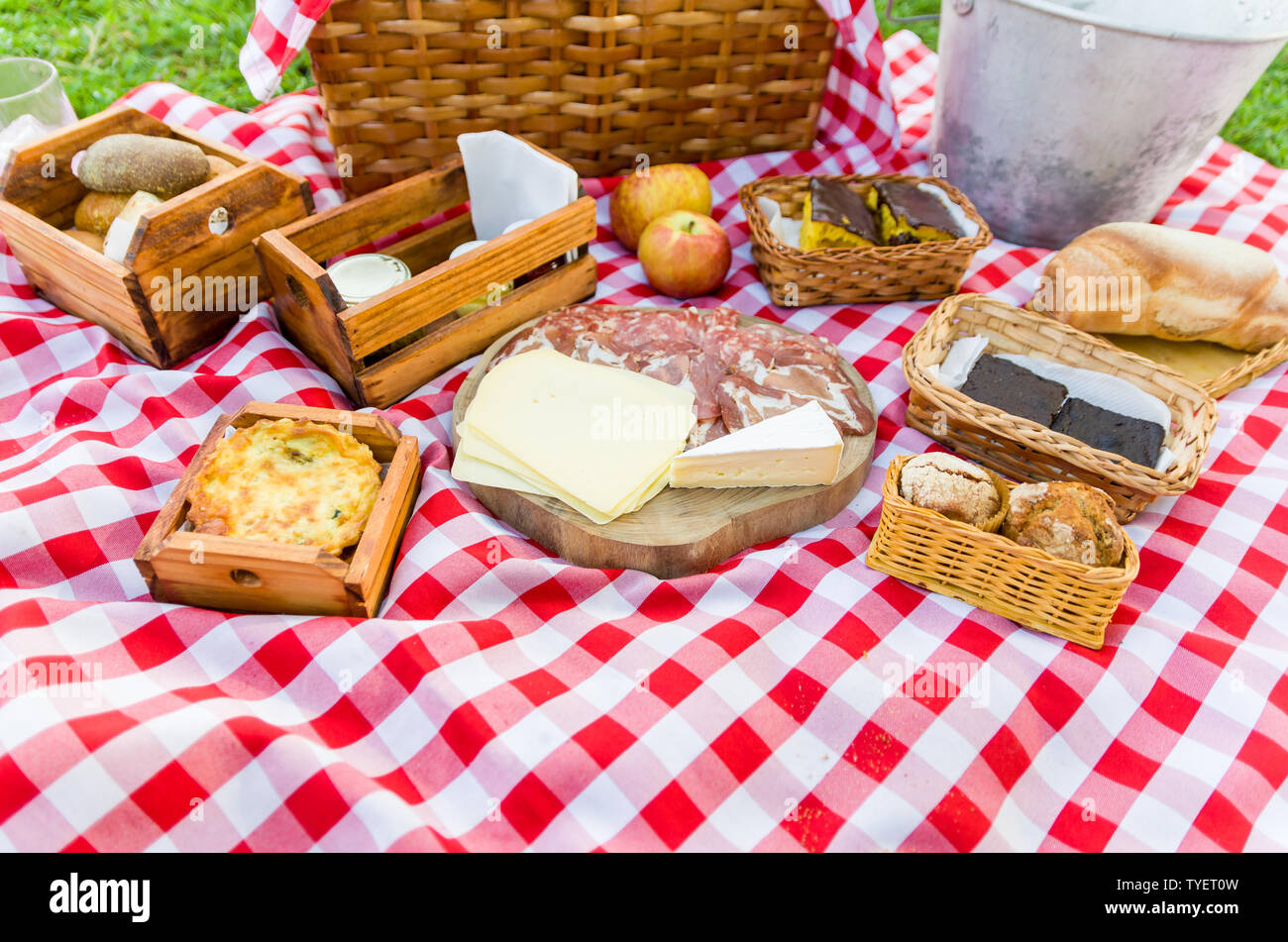 Grande concetto di pic-nic, pic-nic con frutta e succhi di frutta sul prato verde con bella vista Foto Stock