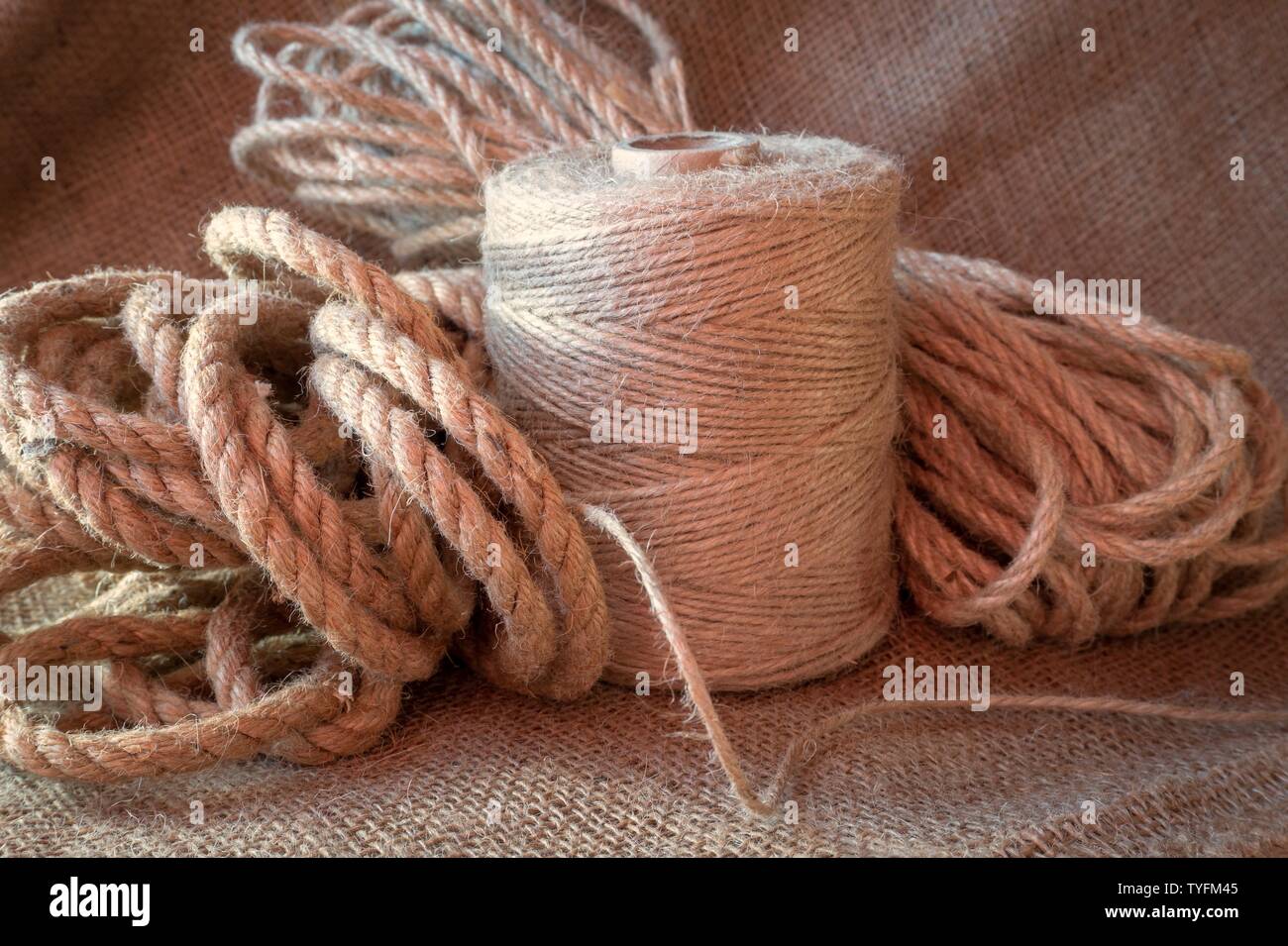 Corda di iuta e rocchetti di fili di tela o di iuta spago su un letto di  sacco in tessuto di close-up Foto stock - Alamy