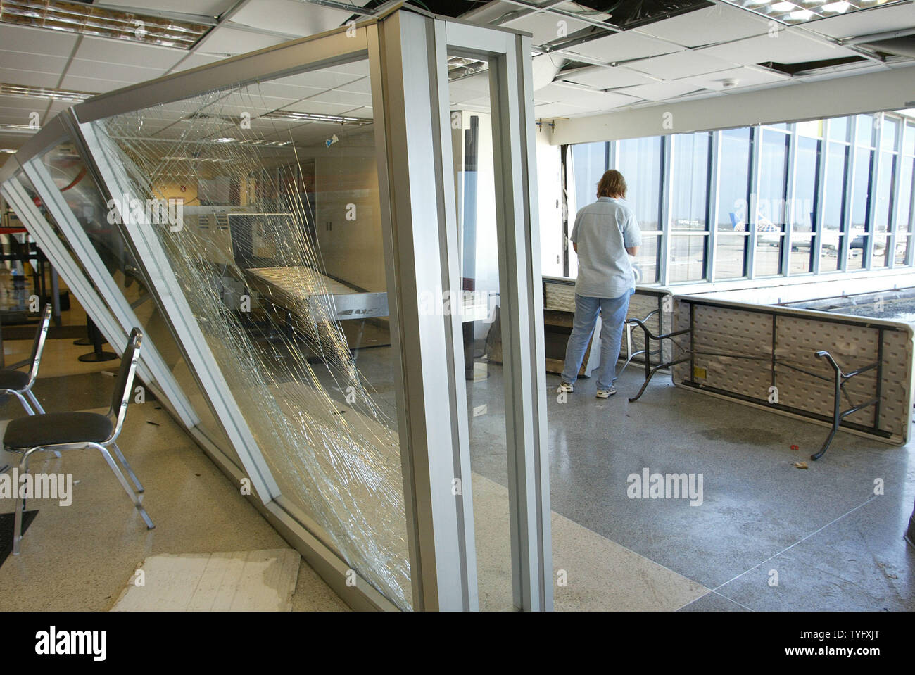 Un aeroporto dipendente di New Orleans''Aeroporto Internazionale Louis Armstrong guarda fuori da una finestra che è stata soffiata fuori quando un tornado toccato durante le prime ore del mattino del 2 febbraio 2006, come una forte tempesta soffiava di sistema attraverso l'area metropolitana. Questa parte della parrocchia di Jefferson fu risparmiato dal devastante alluvione acque dell'uragano Katrina, che ha colpito la zona lo scorso anno.. (UPI foto/A.J. Sisco) Foto Stock
