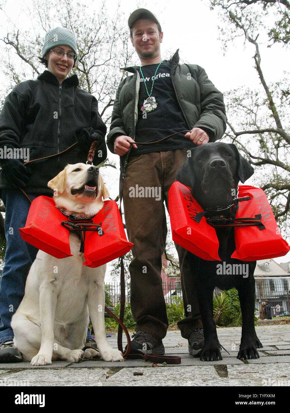 Melissa e Greg Hymel e loro Labrador retriever Sadie, a sinistra e a stella sono pronti per niente al Krewe di cane Barkus parade di New Orleans French Quarter Febbraio 19, 2006 -- anche un proiettore cittadine, come la loro vita giacche dimostrare. I cani sono stati tra centinaia di rivestimento fino a camminare o correre nel Barkus parade con il tema "La procedura guidata delle zampe: non ci è posto come la casa." . (UPI foto/A.J. Sisco) Foto Stock