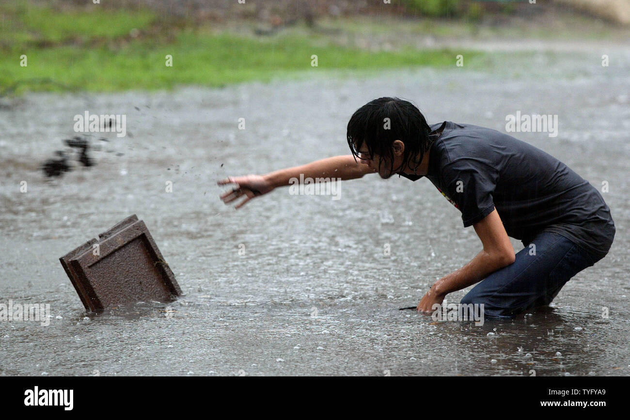 Perry Kantor cerca di pulire un pozzo sulla sua strada allagata in uptown New Orleans il 21 dicembre 2006. Le forti piogge degli ultimi ventiquattro ore riempito molte strade della zona, alcuni con un piede o più di acqua. Le stazioni di pompaggio sono fatica a tenere il passo e vengono osservati da vicino poiché le catastrofiche inondazioni dopo l uragano Katrina nel mese di agosto 2005 danneggiato molte di loro. (UPI foto/A.J. Sisco) Foto Stock