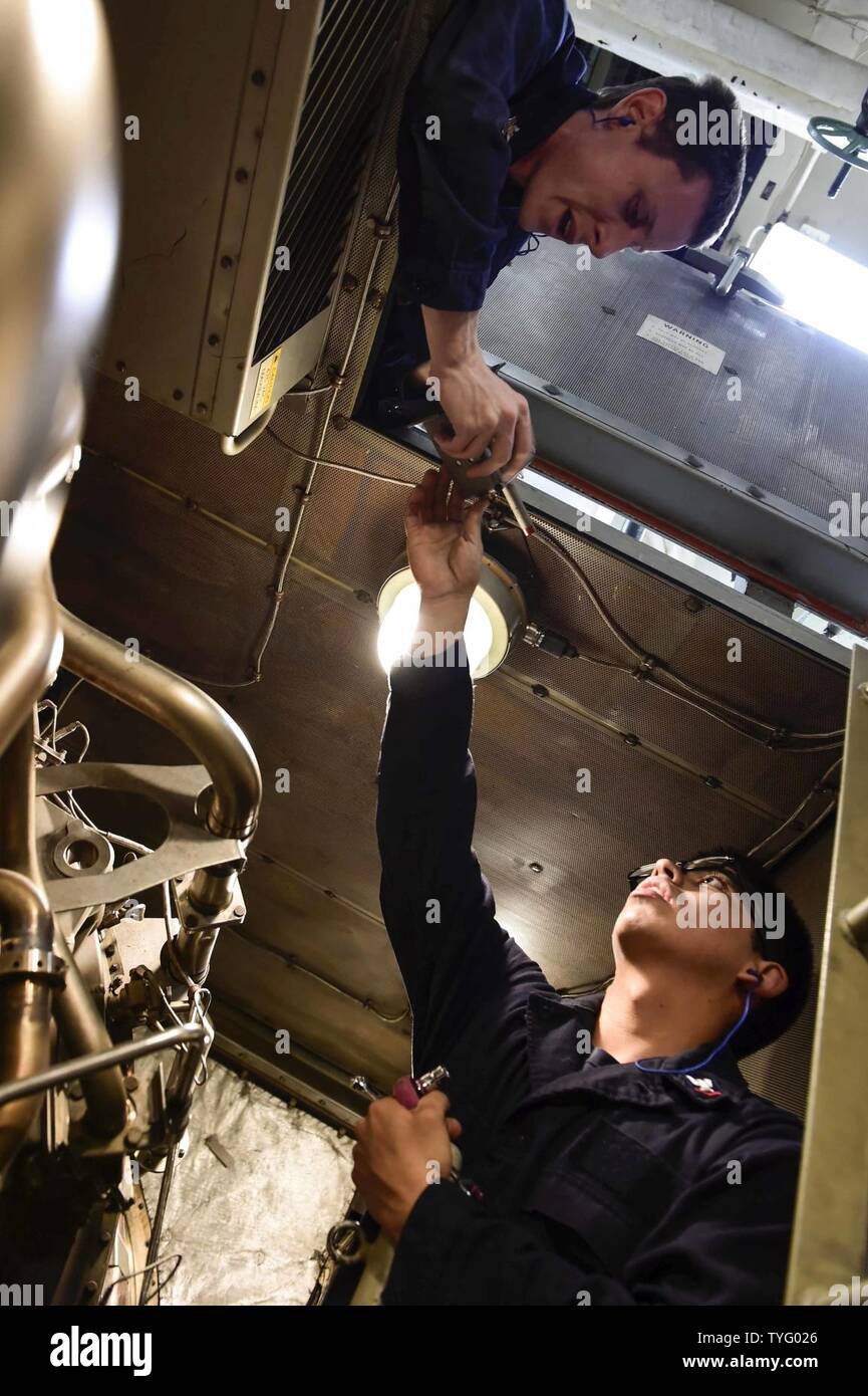 Mare (nov. 7, 2016) Petty Officer 1. Classe Craig Crippon, sinistra, mani Petty Officer di terza classe Justin Santis un interruttore termico durante la manutenzione a bordo della USS Ross (DDG 71). Ross, un Arleigh Burke-class guidato-missile distruttore, distribuita a Rota, Spagna, sta conducendo operazioni navali negli Stati Uniti Sesta flotta area di operazioni a sostegno degli Stati Uniti per gli interessi di sicurezza nazionali in Europa e in Africa. Foto Stock