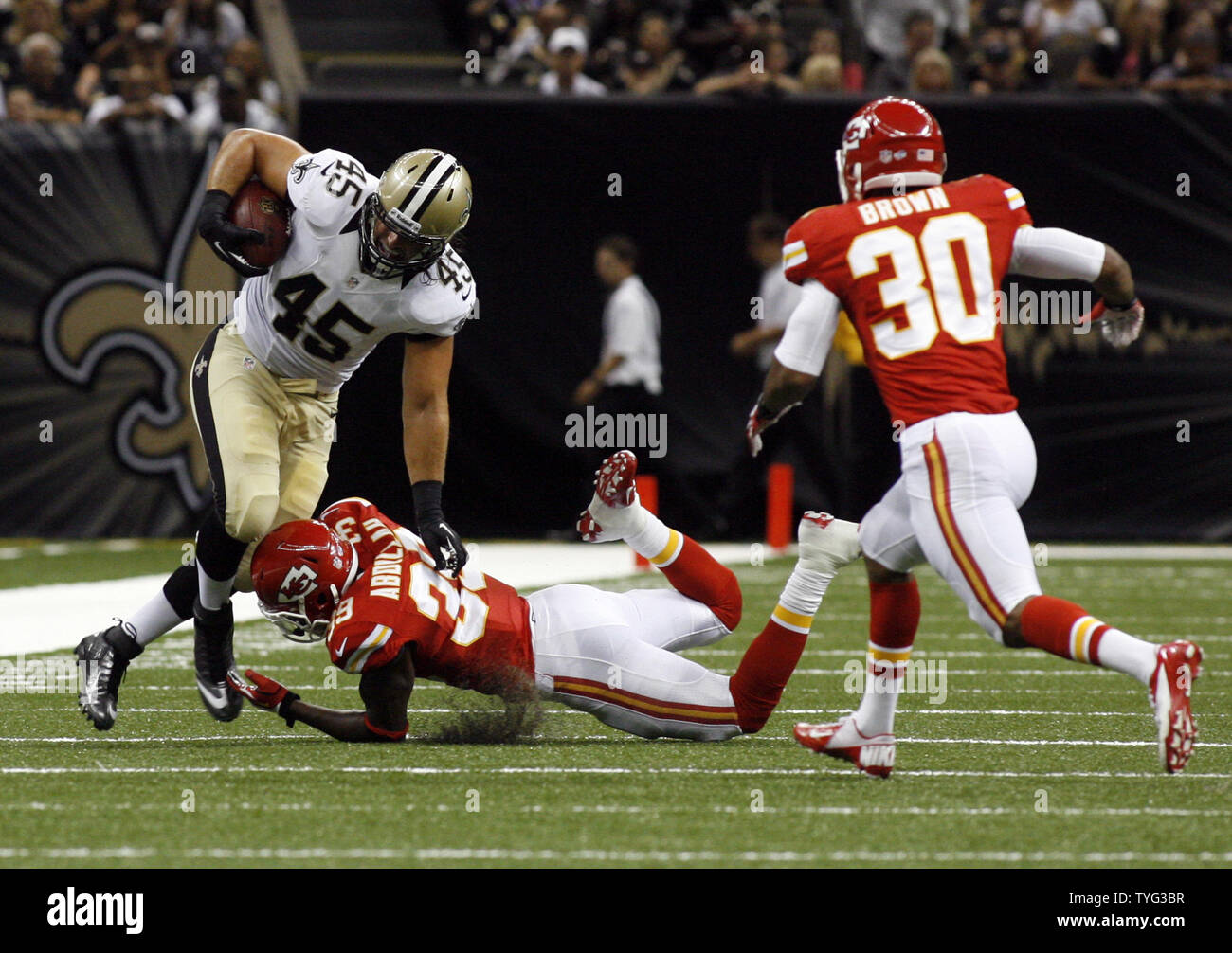 New Orleans Saints fullback Jed Collins (45) assume una Drew Brees passare il campo per un breve gioco prima di essere affrontati da Kansas City Chiefs difensori Husain Abdullah (39) e Jalil marrone (30) presso la Mercedes-Benz Superdome di New Orleans, in Louisiana il 9 agosto 2013. UPI/A.J. Sisco Foto Stock