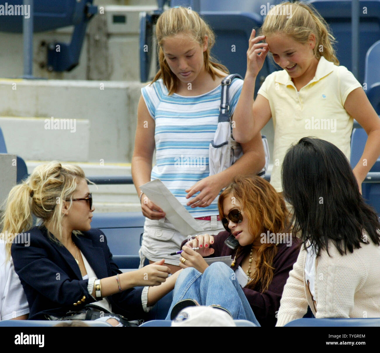 Olson twins Ashley, seduto ,a sinistra e Mary-Kate, seduto a destra, firmare autografi come essi frequentano uomini della semi-finale corrisponde a US Open svoltasi presso il National Tennis Center Settembre 11, 2004 a Flushing Meadows a New York City. (UPI foto/Monika Graff) Foto Stock