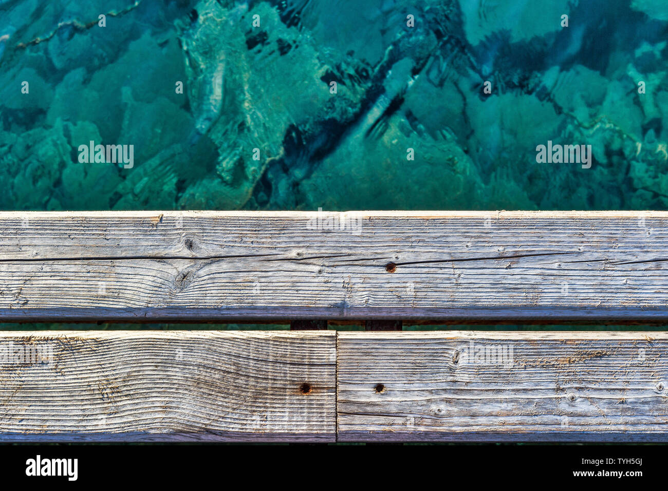 Vista ravvicinata del vecchio dock in legno e acqua turchese. Buona fotografia per il pattern. Foto Stock
