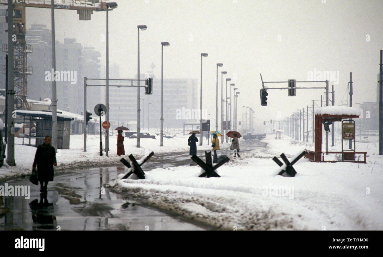 Il 26 marzo 1993 durante l'assedio di Sarajevo: la vista verso ovest lungo Bulevar Meše Selimovića. La popolazione locale a piedi lungo una strada vuota di qualsiasi traffico, attraverso una linea di serbatoio di trap. Foto Stock