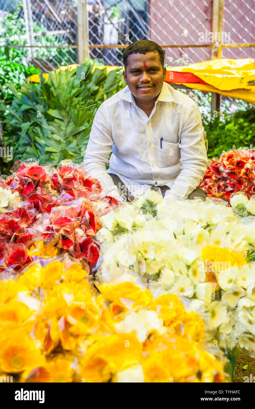 Un uomo che lavora in un mercato dei fiori in Pune, India. Foto Stock