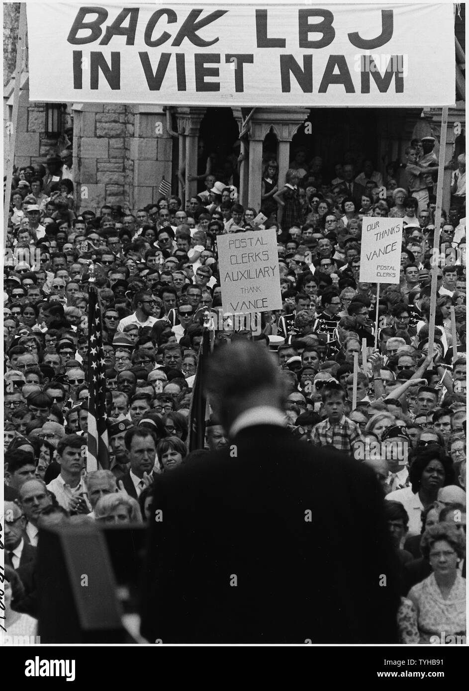 Le reazioni dei cittadini: segni di supporto; la portata e il contenuto: Posizione: Indianapolis, Indiana. Illustrato: Presidente Lyndon B. Johnson, folla. Note generali: una folla di Indianapolis ascolta il presidente Lyndon B. Johnson parlando sotto un cartello che dice che torna LBJ IN VIET NAM Foto Stock
