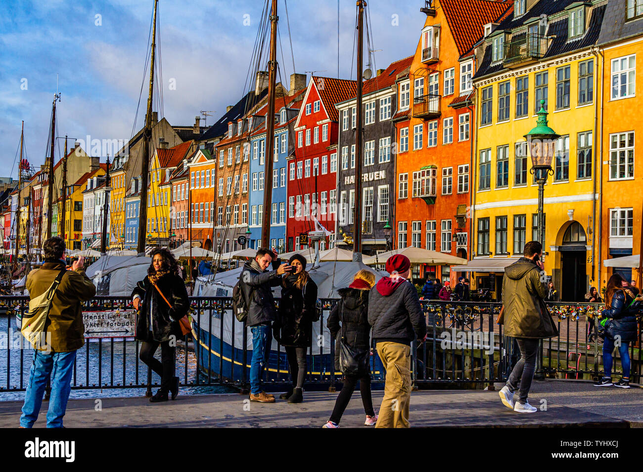 I turisti per scattare delle foto in Nyhavn, un secolo XVII canal e l'area del porto con bar e ristoranti nella città capitale di Copenhagen, Danimarca. 2019. Foto Stock