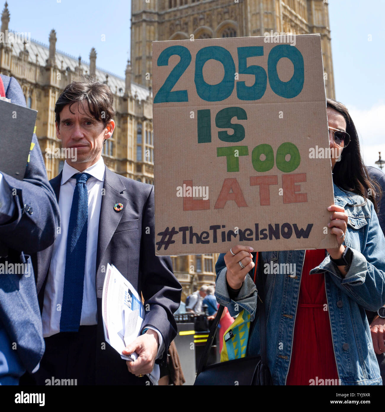 Londra, Regno Unito. Il 26 giugno 2019. Rory Stewart, Segretario di Stato per lo Sviluppo Internazionale e MP per Penrith e la frontiera, passa una donna tenendo come segno durante il "tempo è ora' Hall di massa intorno al Parlamento. Gli attivisti sono il tentativo di consegnare un messaggio a MPs che per affrontare la crisi ambientale, un ambiente forte Bill è passata che è in grado di ripristinare la natura plastica tagliata l'inquinamento e migliorare la qualità dell'aria. Simili incontri si svolgono in tutto il Regno Unito. Credito: Stephen Chung / Alamy Live News Foto Stock