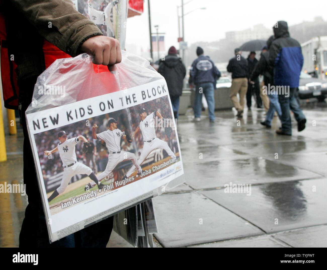 Gaurau Dixit mani fuori i quotidiani gratuiti con poster della sfera di nuovi giocatori al di fuori del Yankee Stadium di New York Yankees tenere il loro ultimo giorno di apertura allo Yankee Stadium di New York il marzo 31,2008. Un nuovo $1.3 ballpark viene costruita adiacente a 'la casa che Ruth costruita' e sarà aperto il prossimo anno. (UPI foto/Monika Graff) Foto Stock