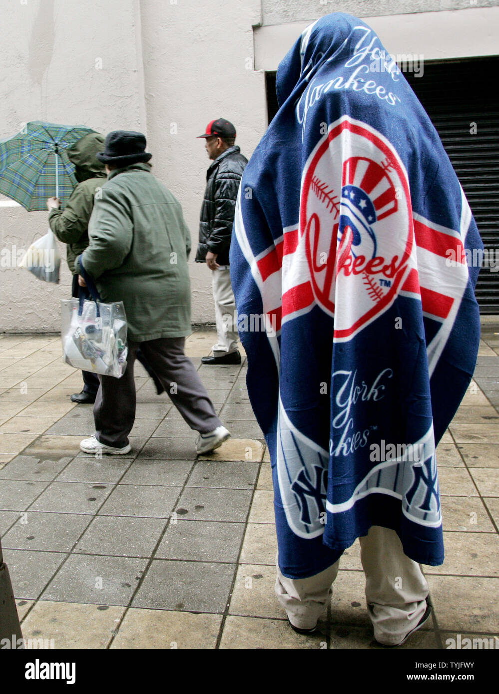 Sabrina giovani rimane asciutto sotto una coperta come come la pioggia si riversa verso il basso come la New York Yankees tenere il loro ultimo giorno di apertura a questo stadio di New York su marzo 31,2008. Un nuovo $1.3 ballpark viene costruita adiacente a 'la casa che Ruth costruita' e sarà aperto il prossimo anno. (UPI foto/Monika Graff) Foto Stock