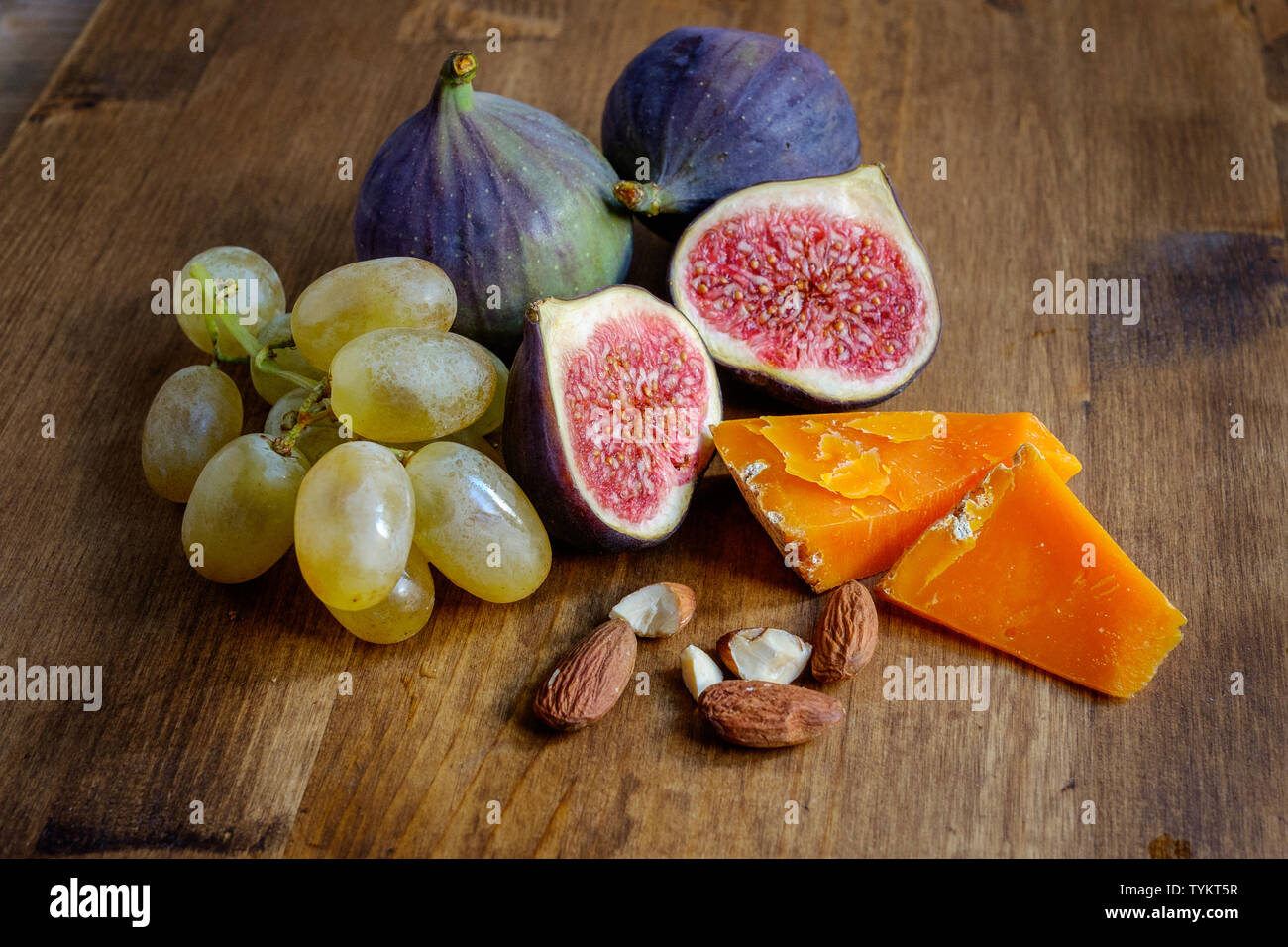 Frutta, noci e formaggio su di un tavolo di legno Foto Stock