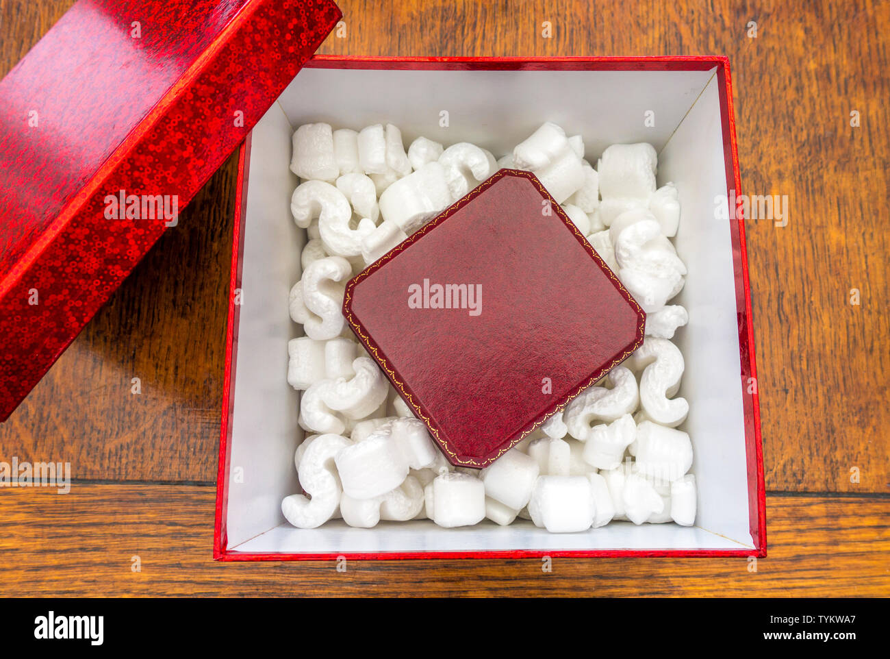 Polistirene Loosefill imballaggio protettivo per la spedizione / distacco scopi, in un cartone rosso box presentazione intorno ad una piccola custodia imbottita. Foto Stock