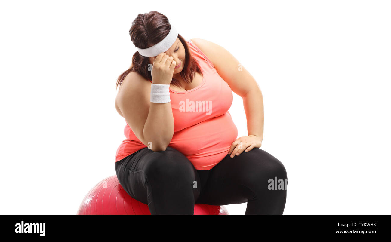 Emotional sovrappeso donna seduta su una palla ginnica isolati su sfondo bianco Foto Stock