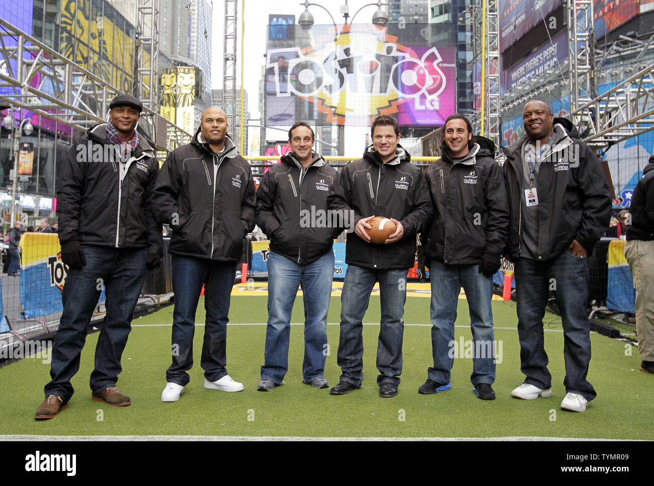 Eddie George, Antonio Pierce, Bill Gramatica, Nick Lachey, Martin Gramatica e Rodney Peete (R) stand con un calcio prima di calciare un field goal come essi cercano di aiutare a stabilire un nuovo Guinness World Record titolo per la maggior parte delle persone a calci con successo un american football field goal in sei ore consecutive in Times Square a New York City il 16 dicembre 2011. UPI/John Angelillo Foto Stock