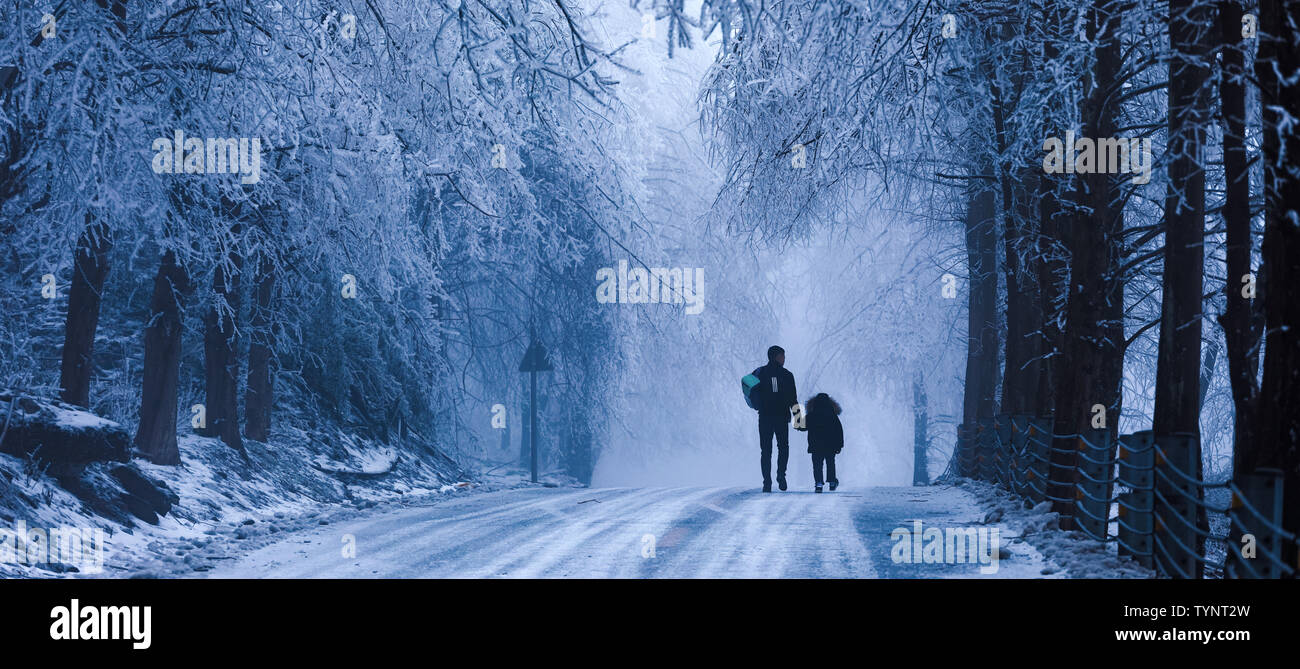 Papà ha avuto il suo figlio la mano e abbiamo camminato lungo la congelati strada di montagna. Foto Stock
