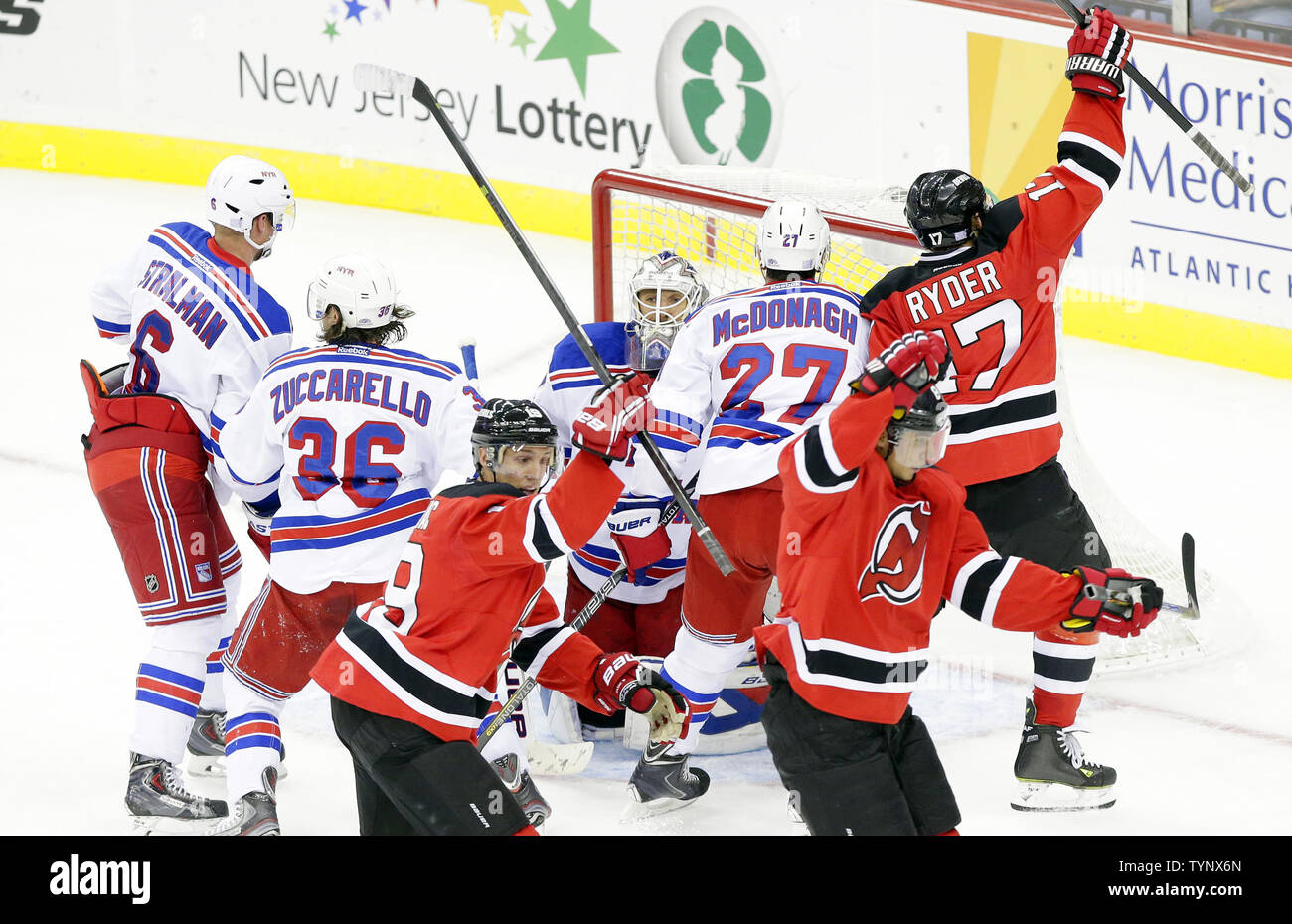 New York Rangers Henrik Lundqvist, Ryan McDonagh, Mats Zuccarello e Anton Stralman watch New Jersey Devils Travis Zajac, Daniele Zubrus e Michael Ryder a reagire dopo Zubrus segna un punto nel secondo periodo al Prudential Center a Newark, New Jersey il 19 ottobre 2013. UPI/John Angelillo Foto Stock