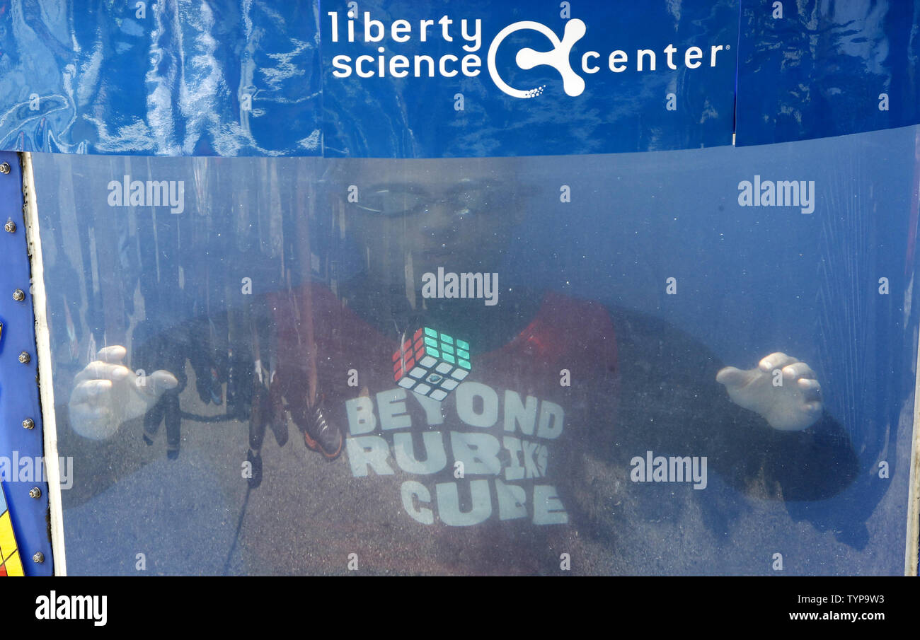 North American velocità campione del cubo di Anthony Brooks si siede in un serbatoio di acqua dopo egli rompe il Guinness dei Record per la maggior parte il cubo di Rubik rompicapo risolto sott'acqua in un respiro a livello nazionale RubikÕs Cube campionato al Liberty Science Center di Jersey City, NJ il 1 agosto 2014. Brooks impostare un nuovo record di risoluzione di 5 cubi in 1:18 battendo il vecchio record di registrazione di 4 cubi risolto in 1:30. Foto Stock