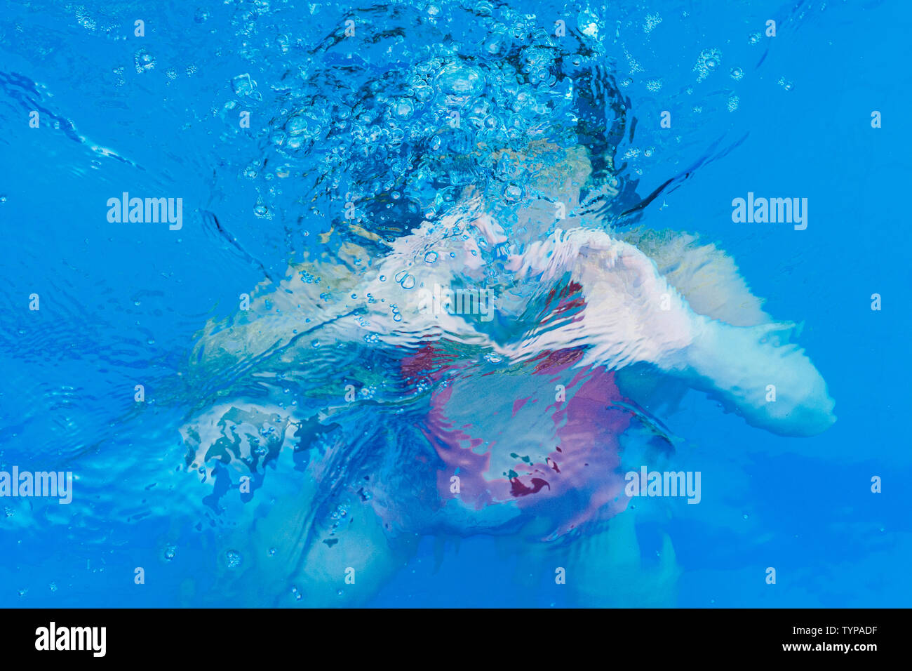 Ragazza forma un cuore sotto acqua in bolle e schizzi Foto Stock