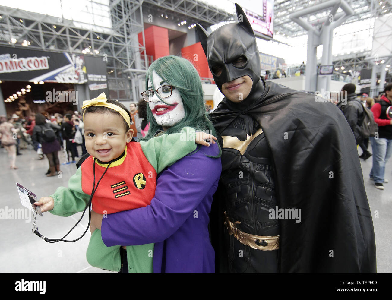Un uomo, donna e bambino vestito come Batman e il Joker e Robin