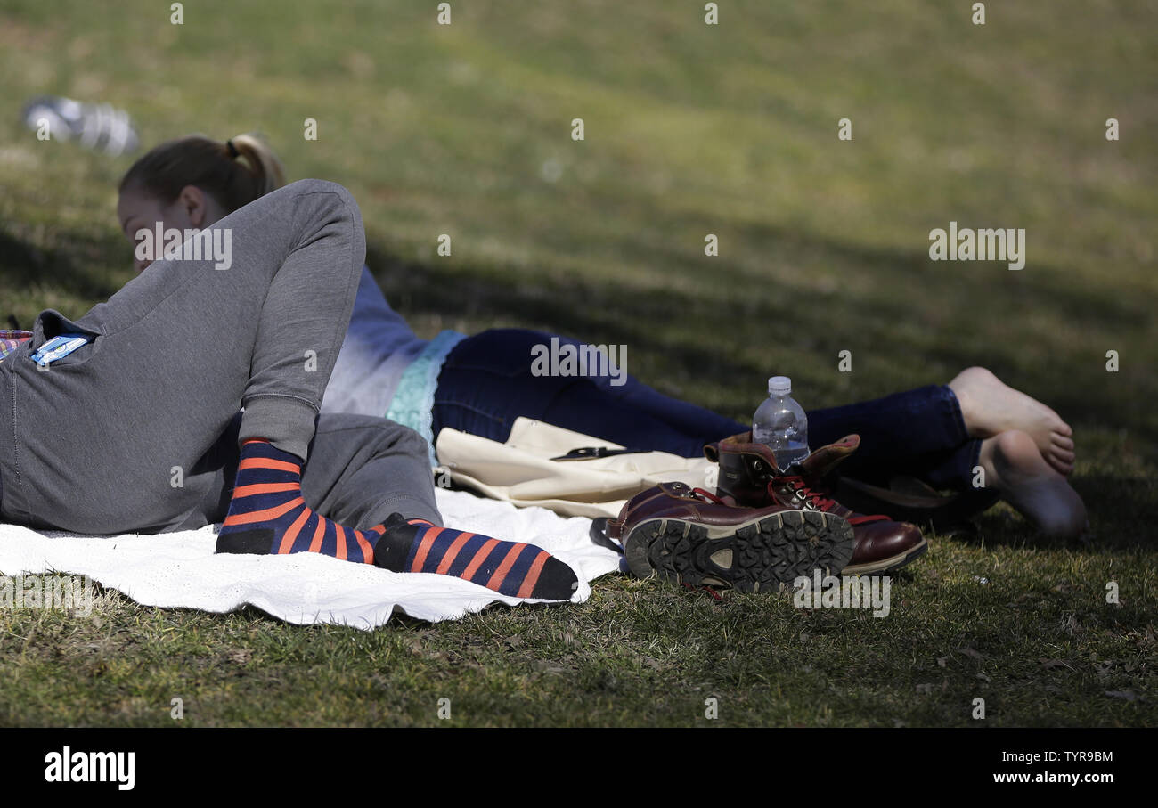 Un uomo e una donna resto sul prato con le loro scarpe off nel Central Park  di New York City il 9 marzo 2016. La città di New York ha stabilito un