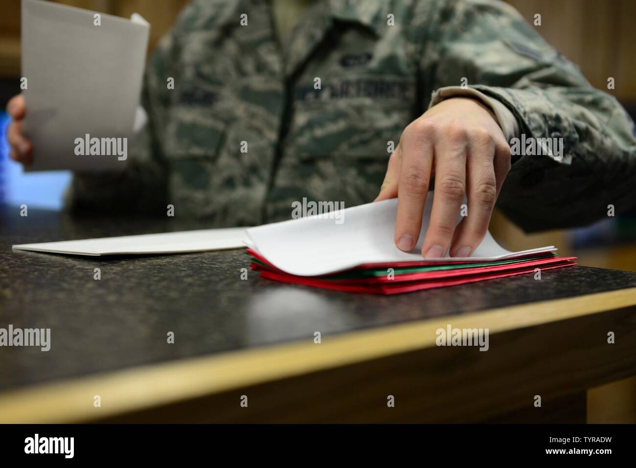 Stati Uniti Air Force Airman 1. Classe Lisa Rogers, un 354Operations Support Squadron previsioni meteo apprendista, raggiunge per una lettera nov. 22, 2016 a Eielson Air Force Base in Alaska. Rogers e il volo meteo inviare centinaia di lettere di Santa ogni anno per i bambini di tutto il mondo come parte della "Santa il giro di posta" programma avviato più di 60 anni fa. Foto Stock