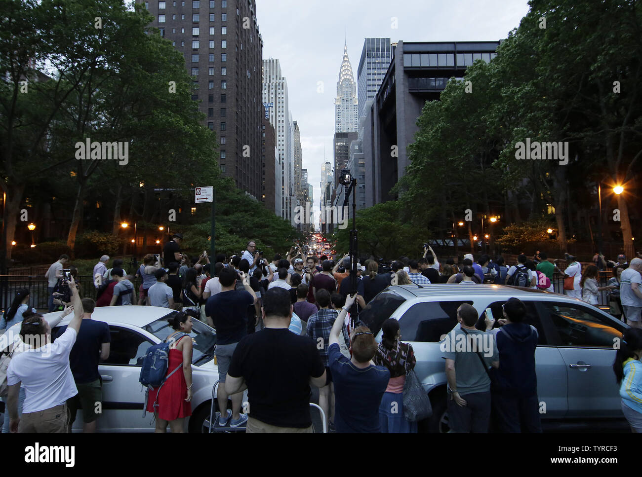 Le persone si radunano e scattare foto con una vista della 42nd Street a Manhattan con la speranza di vedere un evento Manhattanhenge che non potrebbero mai essere visualizzato a causa di nuvole pesanti nella città di New York il 29 maggio 2016. Il Manhattanhenge tramonto arriva due volte l'anno quando il sole al tramonto si allinea proprio con la Manhattan's street griglia. Foto di Giovanni Angelillo/UPI Foto Stock