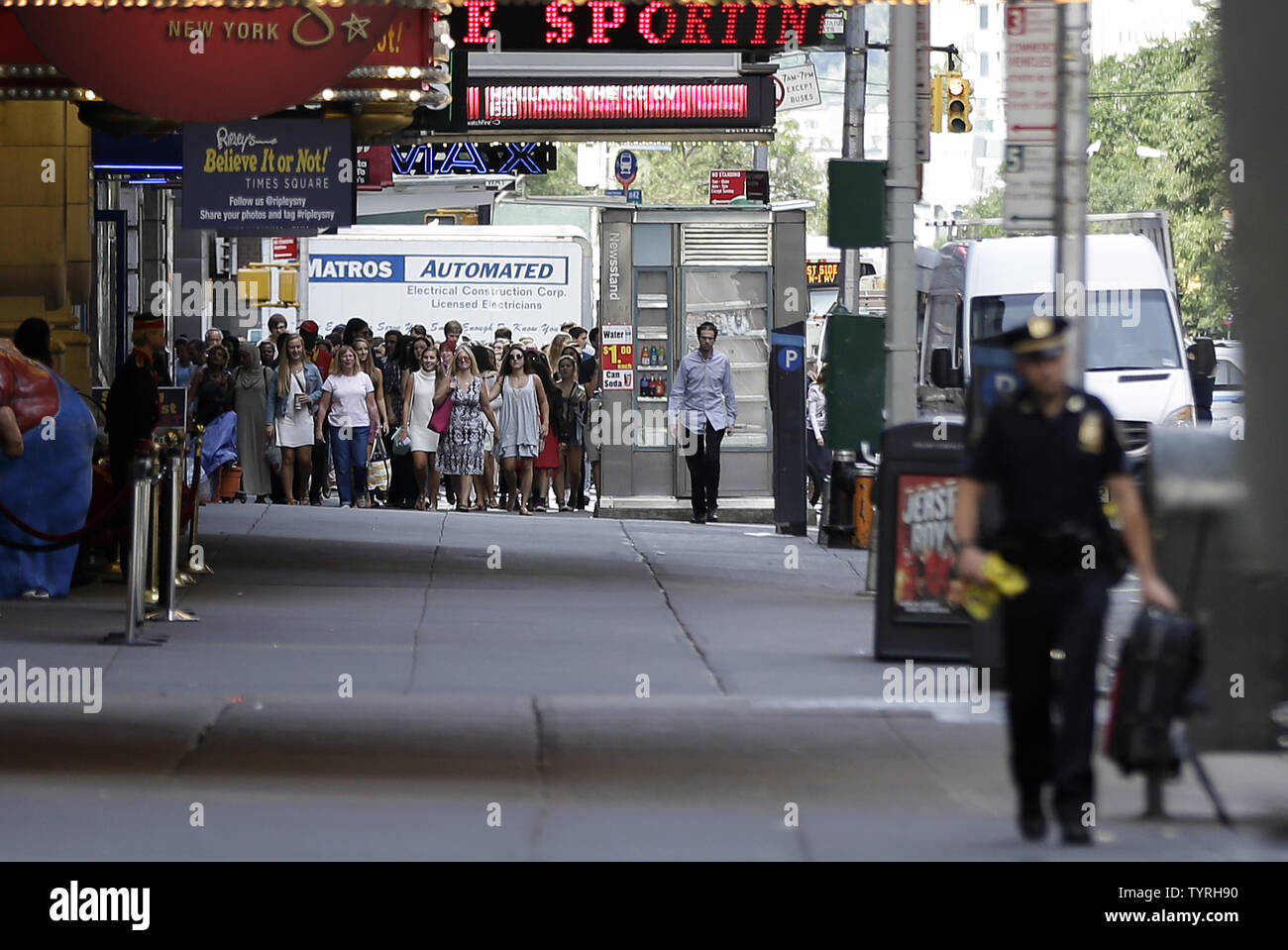 Pedoni guarda come NYPD un funzionario di polizia porta via un sacco di Times Square dopo le relazioni di un pacchetto sospetto inviato forze di polizia e la Bomb Squad di scena il 21 settembre 2016 a New York City. Il pacchetto si è rivelata essere una valigia vuota e del tutto chiaro è stato dato poco dopo. Le tensioni sono ancora alta giorni dopo l'esplosione di una bomba è andato fuori sulla West 23rd Street a Manhattan su Sabato, ferendo 29 persone, fracassando windows e richiede una diffusa street chiusure su West 23rd Street. Foto di Giovanni Angelillo/UPI Foto Stock