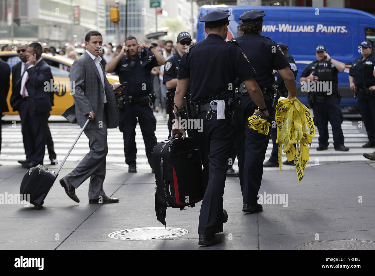 Un NYPD funzionario di polizia porta via un sacco di Times Square dopo le relazioni di un pacchetto sospetto inviato forze di polizia e la Bomb Squad di scena il 21 settembre 2016 a New York City. Il pacchetto si è rivelata essere una valigia vuota e del tutto chiaro è stato dato poco dopo. Le tensioni sono ancora alta giorni dopo l'esplosione di una bomba è andato fuori sulla West 23rd Street a Manhattan su Sabato, ferendo 29 persone, fracassando windows e richiede una diffusa street chiusure su West 23rd Street. Foto di Giovanni Angelillo/UPI Foto Stock