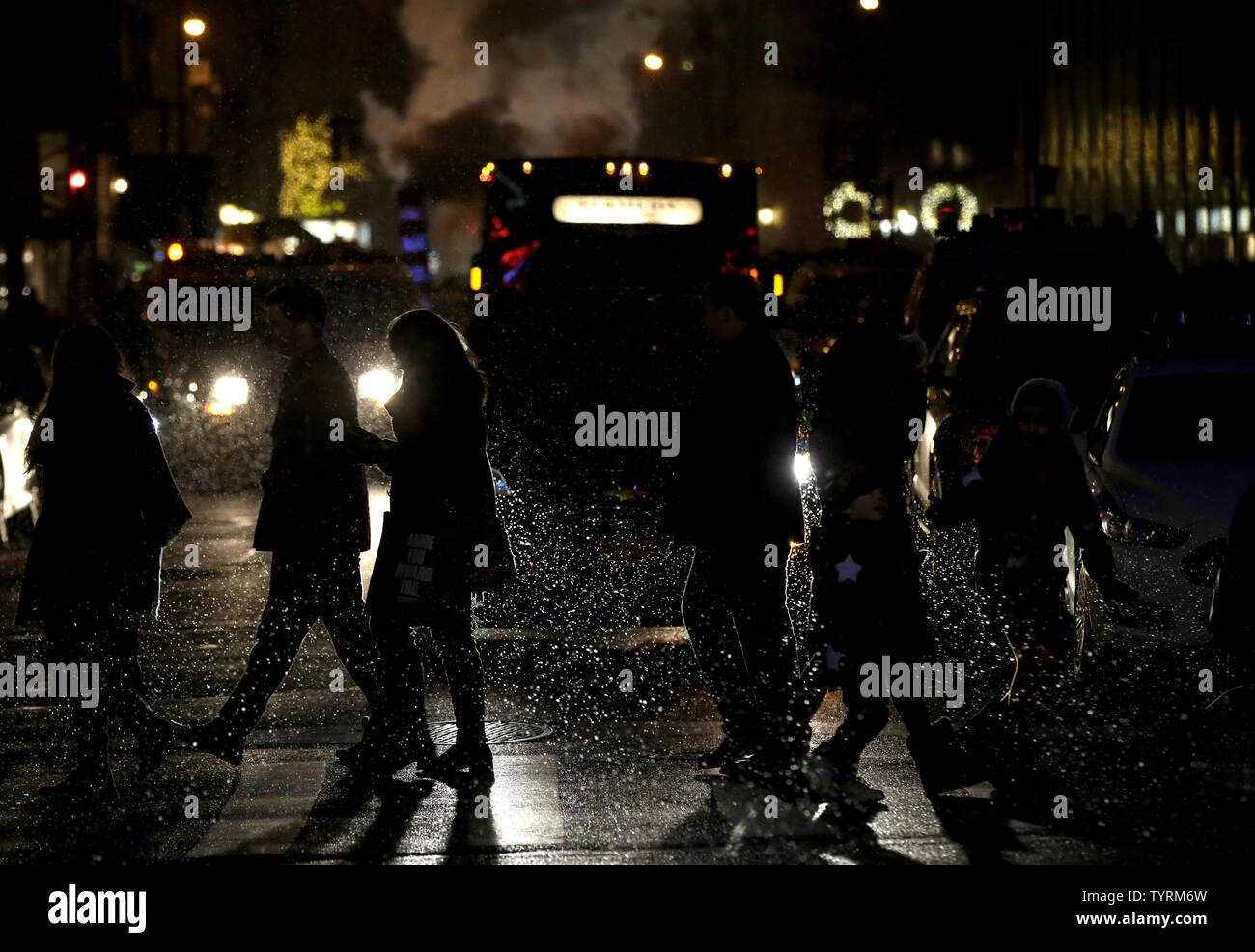 Persone di attraversare la strada nella neve su Madison Avenue a New York City il 11 dicembre 2016. Un mix invernale di neve, nevischio pioggia ha fatto il suo modo di zona di New York di domenica sera. Foto di Giovanni Angelillo/UPI Foto Stock
