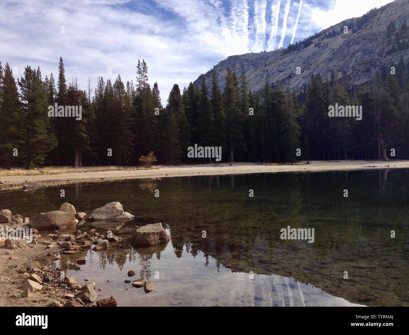 Una montagna e gli alberi si riflette in un lago vetroso Foto Stock