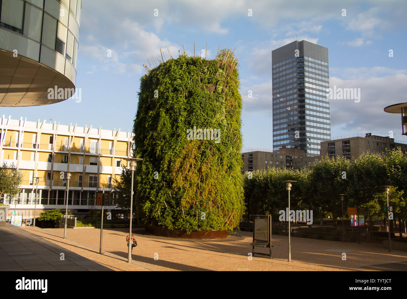 Parigi, Francia - 10 Luglio 2018: grande aiuola con alberi verdi accanto al vetro moderno alto edificio grattacieli e cielo blu backgroundin il distretto di Foto Stock