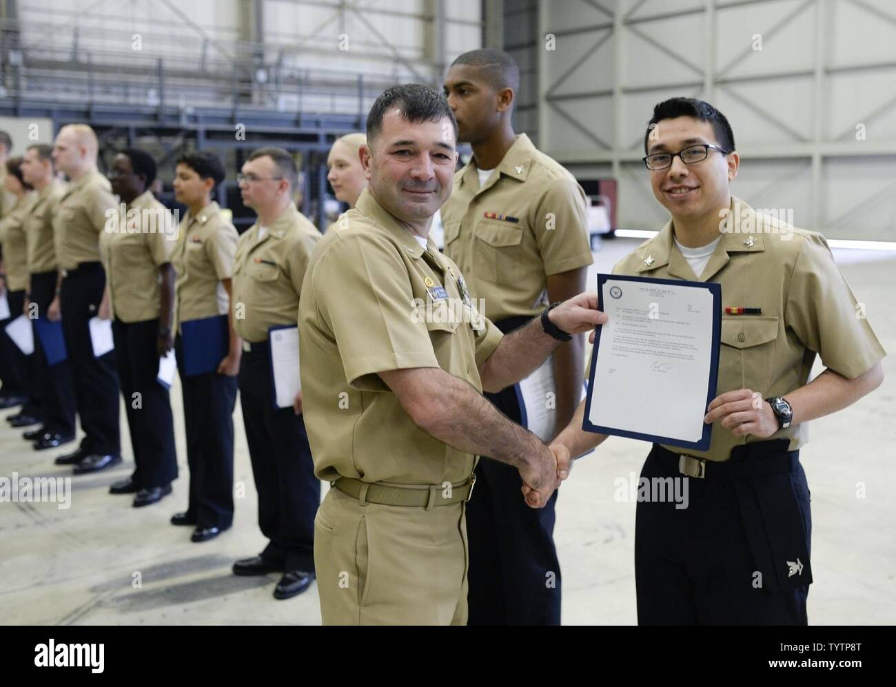 NAS Sigonella, Sicilia (nov. 29, 2016) Naval Air Station (NAS) Sigonella Comandante Capt. Brent Trickel presenta un frocking lettera a una nuova frocked Petty Officer di terza classe Matteo Torrez durante una cerimonia frocking, nov. 29. Venti-sei marinai sono stati frocked al successivo livello retributivo di E-4, E-5 o E-6. NAS Sigonella è un funzionamento a terra base che consente a Stati Uniti, alleati e partner le forze della nazione di essere dove sono necessari e quando essi sono necessari per garantire la sicurezza e la stabilità in Europa, Africa e Asia sud-ovest. Foto Stock