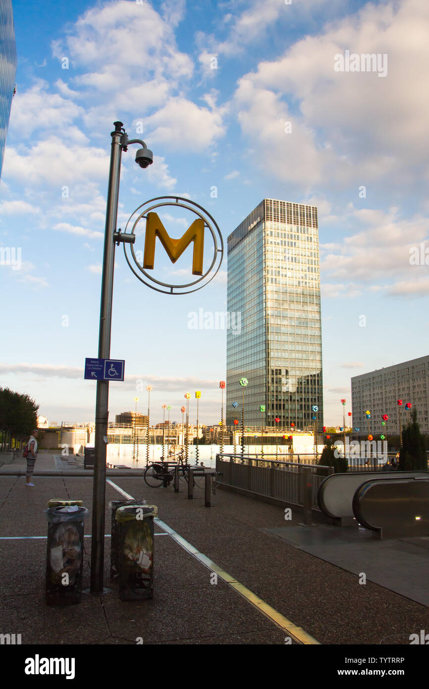 Parigi, Francia - 10 Luglio 2018: La grande lettera M oltre i grattacieli mostra l'entrata del metro nel quartiere degli affari di Paris La Defense Foto Stock