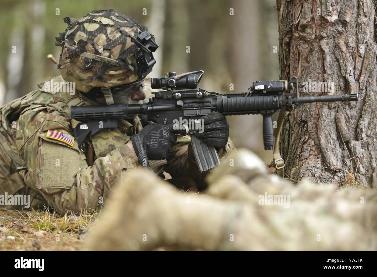 Stati Uniti Army Sgt. Caleb Scanlan, paracadutista, società D, 2° Battaglione, 503rd Reggimento di Fanteria, 173rd Brigata Aerea, tiene il coperchio dietro ad un albero mentre la cottura un M4: 5,56mm Carbine fucile da assalto mentre partecipa un piede smontato patrol durante l'unità di fuoco cumulativo evento di formazione a Wedrzyn, Polonia, nov. 30, 2016. Questa è stata la formazione culminante evento utilizzando tutti gli asset tattici in combinazione uno con l'altro durante la chiusura fuori l'unità di rotazione in Polonia e il suo continuo sostegno del funzionamento risolvere atlantico e i suoi alleati della NATO. Stati Uniti e nazioni partner condotta terra, mare e Foto Stock