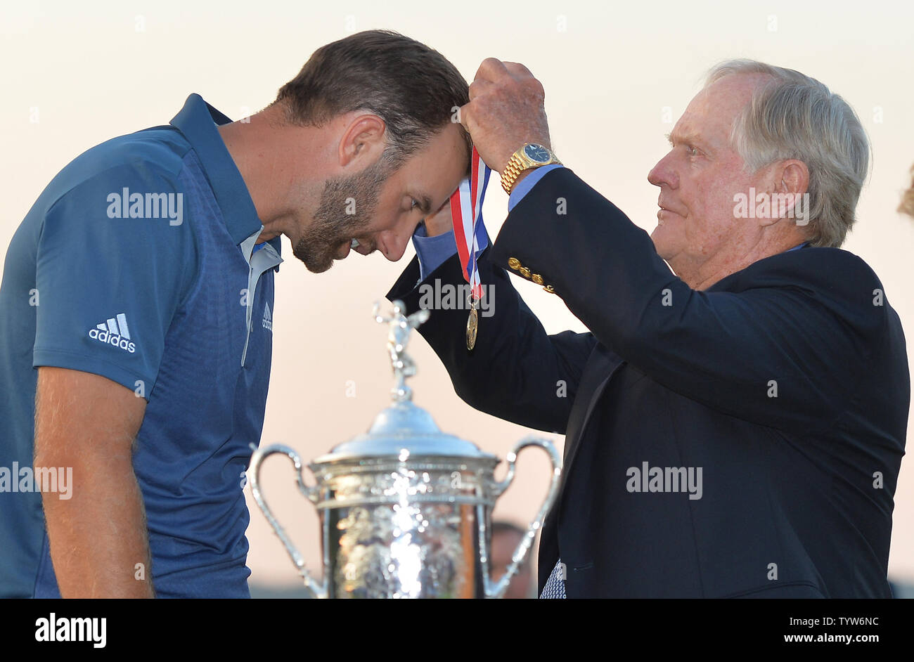 La leggenda del Golf Jack Nicklaus mette una medaglia attorno al collo di Dustin Johnson Vicino Campionato trofeo su xviii verde dopo Johnson vince il suo primo campionato importante nel round finale presso l'U.S. Aperto a Oakmont Country Club vicino Pittsburgh, Pensilvania il 19 giugno 2016. Johnson ha vinto con un punteggio di 5 sotto il par. Foto di Kevin Dietsch/UPI Foto Stock