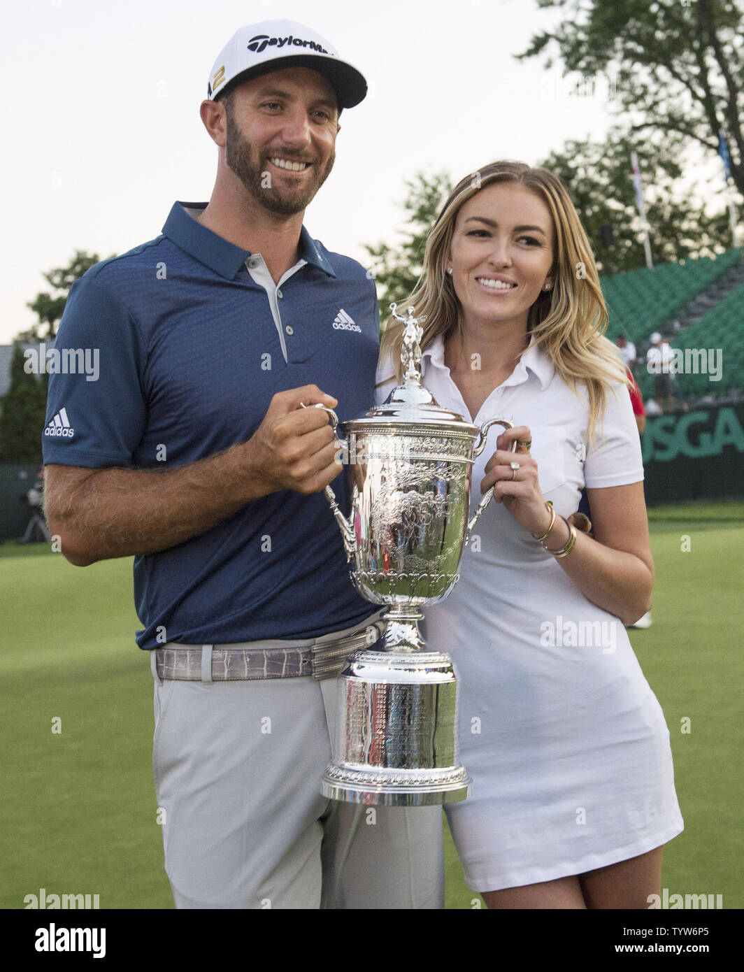 Dustin Johnson si erge con Paulina Gretzky quando detiene il Campionato trofeo su xviii verde dopo aver vinto il suo primo campionato importante nel round finale presso l'U.S. Aperto a Oakmont Country Club vicino Pittsburgh, Pensilvania il 19 giugno 2016. Johnson ha vinto con un punteggio di 5 sotto il par. Foto di Kevin Dietsch/UPI Foto Stock
