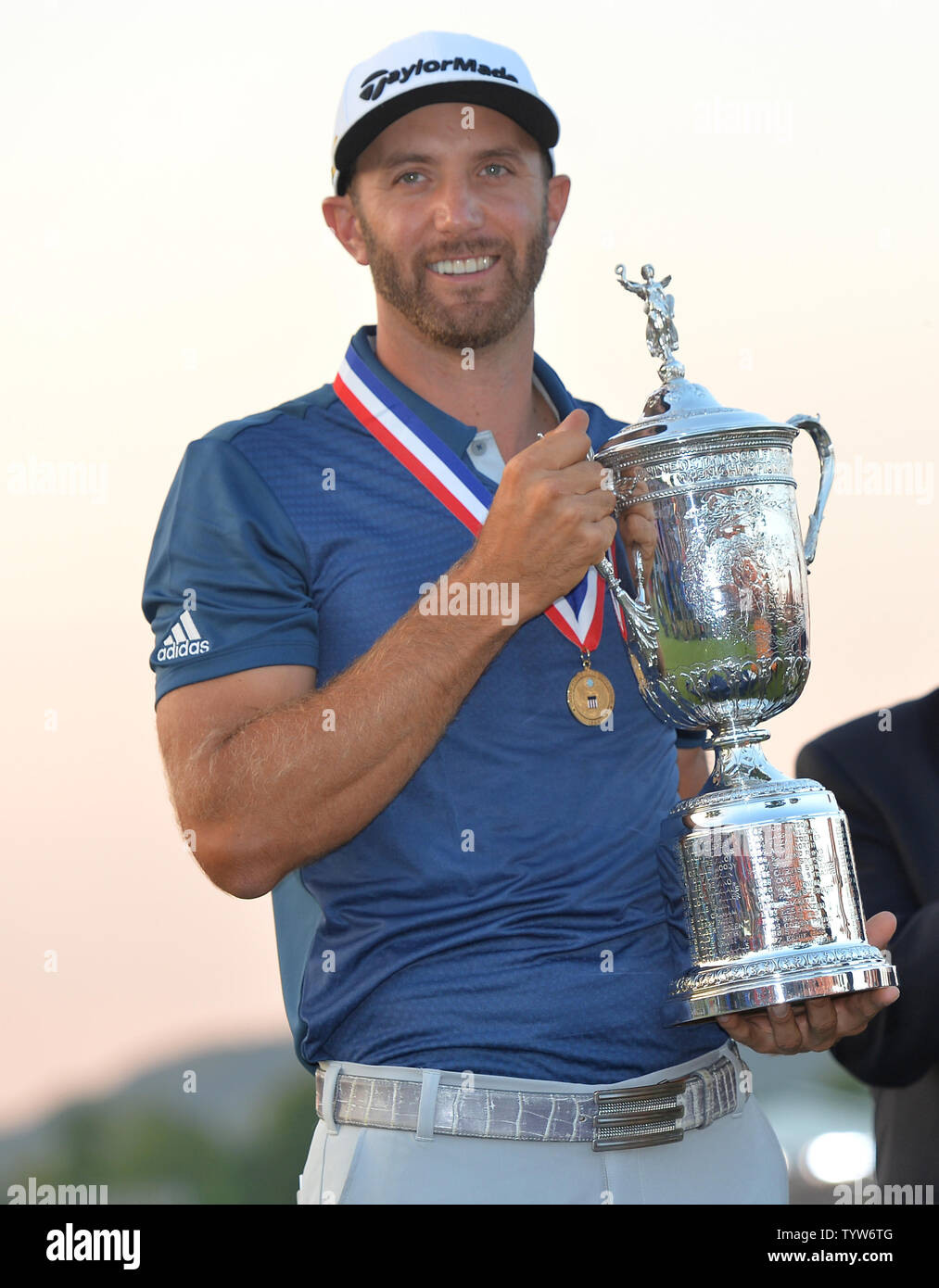 Dustin Johnson detiene il Campionato trofeo su xviii verde dopo aver vinto il suo primo campionato importante nel round finale presso l'U.S. Aperto a Oakmont Country Club vicino Pittsburgh, Pensilvania il 19 giugno 2016. Johnson ha vinto con un punteggio di 5 sotto il par. Foto di Kevin Dietsch/UPI Foto Stock