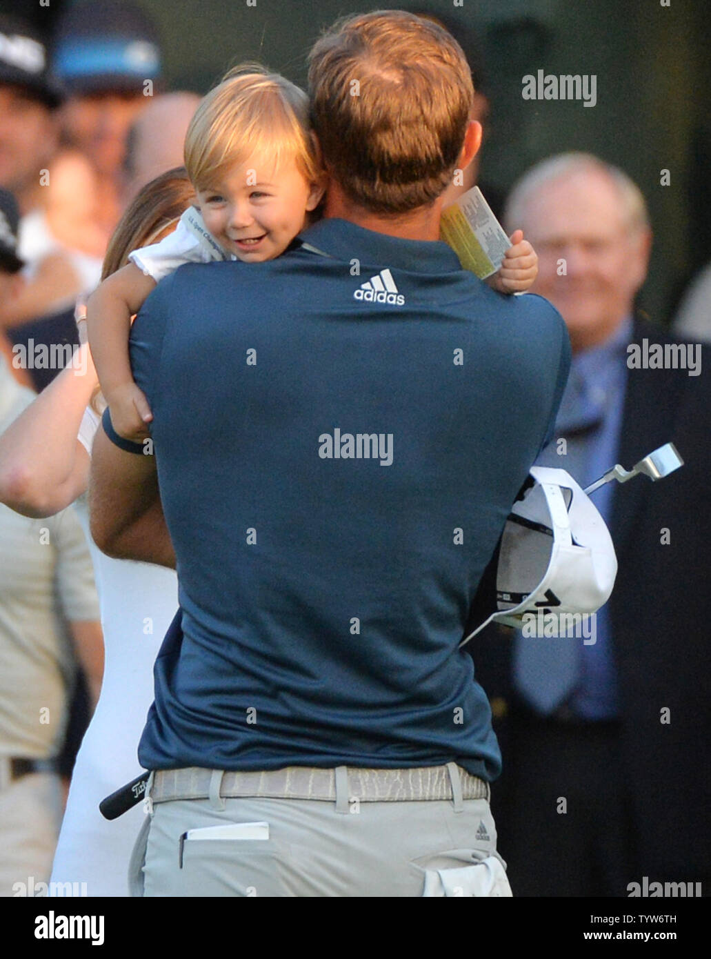 Dustin Johnson detiene il figlio Tatum quando egli celebra il diciottesimo verde dopo la realizzazione di un birdie putt e a vincere il suo primo campionato importante nel round finale presso l'U.S. Aperto a Oakmont Country Club vicino Pittsburgh, Pensilvania il 19 giugno 2016. Johnson ha vinto con un punteggio di 5 sotto il par. Foto di Kevin Dietsch/UPI Foto Stock