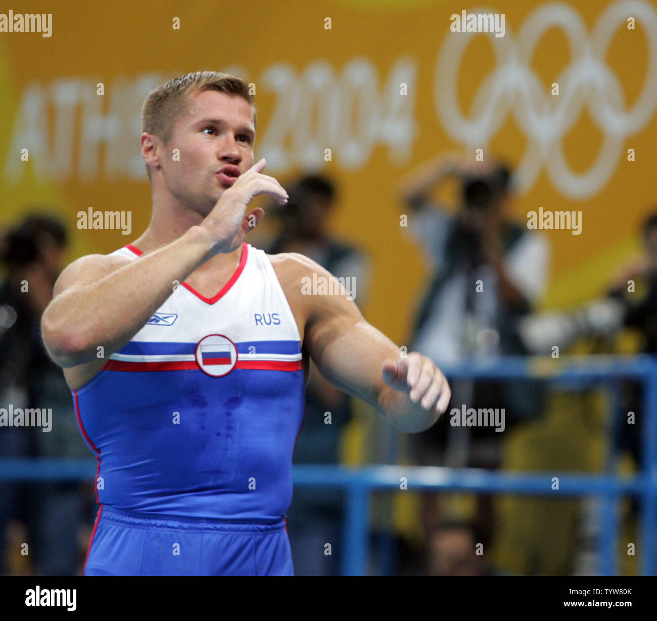 Ginnasta russo Alexei Nemov tenta di tranquillo il pubblico che fischiato senza sosta presso i giudici a seguito della sua alta bar routine finali al Athens Olympic Indoor Hall il 23 agosto 2004. I giudici provenienti da Canada e della Malaysia hanno chiesto di giustificare le loro deduzioni e sollevato i loro punteggi 0,1 e 0,15, rispettivamente. Nemov è di nuovo cliente ancora mantenuto lui fuori delle medaglie (UPI foto / Grazia Chiu) Foto Stock