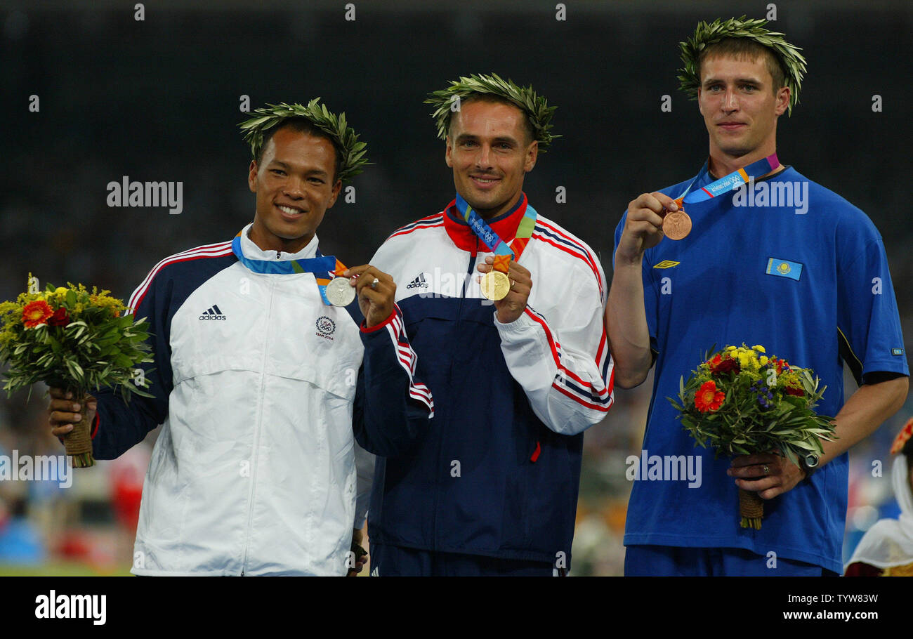 Sul podio L. per R. Bryan argilla, STATI UNITI D'AMERICA (argento), Roman Sebrle (oro), e Dmitriy Karpov (bronzo) in Uomini Decathlon finale nello stadio olimpico di Atene del 2004 Giochi Olimpici Estivi, Agosto 25, 2004. (UPI Photo/ Claus Andersen) Foto Stock