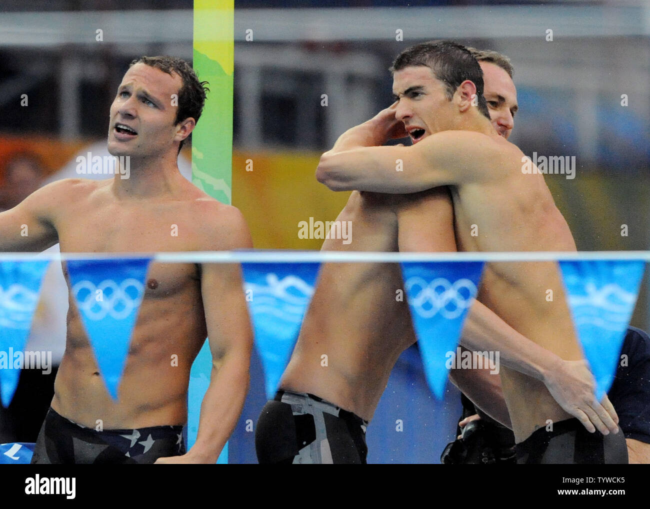 USA i membri del team Brendan Hansen (L) cheers come Aaron Peirsol (C) e Michael Phelps (R) abbracciarsi come il loro compagno di squadra Jason Lezak bordi fuori Australia sull ultima tappa dell'uomo 4x100M Relè Medley evento presso il National Aquatics Centre Giochi Olimpici Estivi a Pechino il 17 agosto 2008. Il team USA ha vinto l'oro con un mondo un tempo record di 3:29,34 e Phelps impostare un singolo record olimpico di otto medaglie d oro. (UPI foto/Pat Benic) Foto Stock