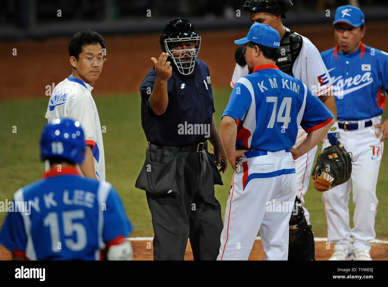 Homeplate arbitro Carlos Rey cotto (C) invita la Corea del Yongkyu Lee (15) torna alla piastra dopo Lee ha sostenuto che egli era stato colpito da un passo durante il sesto inning azione contro Cuba,a Wukesong Baseball Field, Agosto 23, 2008, Giochi Olimpici Estivi a Pechino, in Cina. Corea del gestore Kyungmoon Kim (74) ha cercato di intervenire. La Corea ha vinto 3-2, per la medaglia d'oro. Alle Olimpiadi è la caduta di baseball come un funzionario dello sport, avviato per la prima volta al 1984 Olimpiadi. (UPI foto/Mike Theiler) Foto Stock