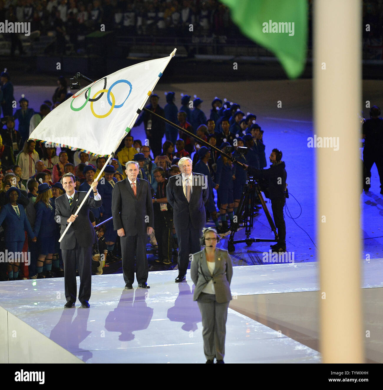 Eduardo Paes, sindaco di Rio de Janeiro, (L-R) tiene la bandiera olimpica come si sta con Jacques Rogge, presidente del Comitato Olimpico Internazionale, (C) e Boris Johnson, sindaco di Londra come la bandiera brasiliana è sollevato e il Brasiliano inno nazionale suonato durante la cerimonia di chiusura per il London 2012 Olimpiadi di estate il 12 agosto 2012 a Stratford, Londra. I prossimi giochi olimpici estivi saranno nel 2016 a Rio de Janeiro. UPI/Brian Kersey Foto Stock