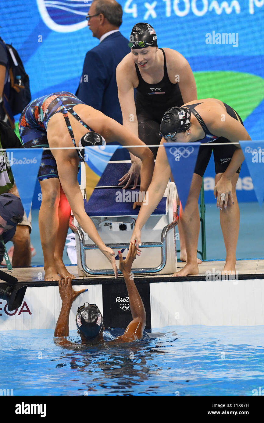 Stati Uniti d'America's Simone Manuel, si congratula con i compagni di squadra Dana Vollmer, sinistra, Lilly Re e Kathleen Baker dopo aver vinto l'oro nel femminile 4 x 100m relè medley finale alla Olympic Aquatics Stadium presso il Rio 2016 Olimpiadi di estate a Rio de Janeiro, Brasile, il 13 agosto 2016. Gli Stati Uniti hanno vinto la medaglia d'oro, Australia l'argento e la Danimarca il bronzo. Foto di Richard Ellis/UPI.. Foto Stock