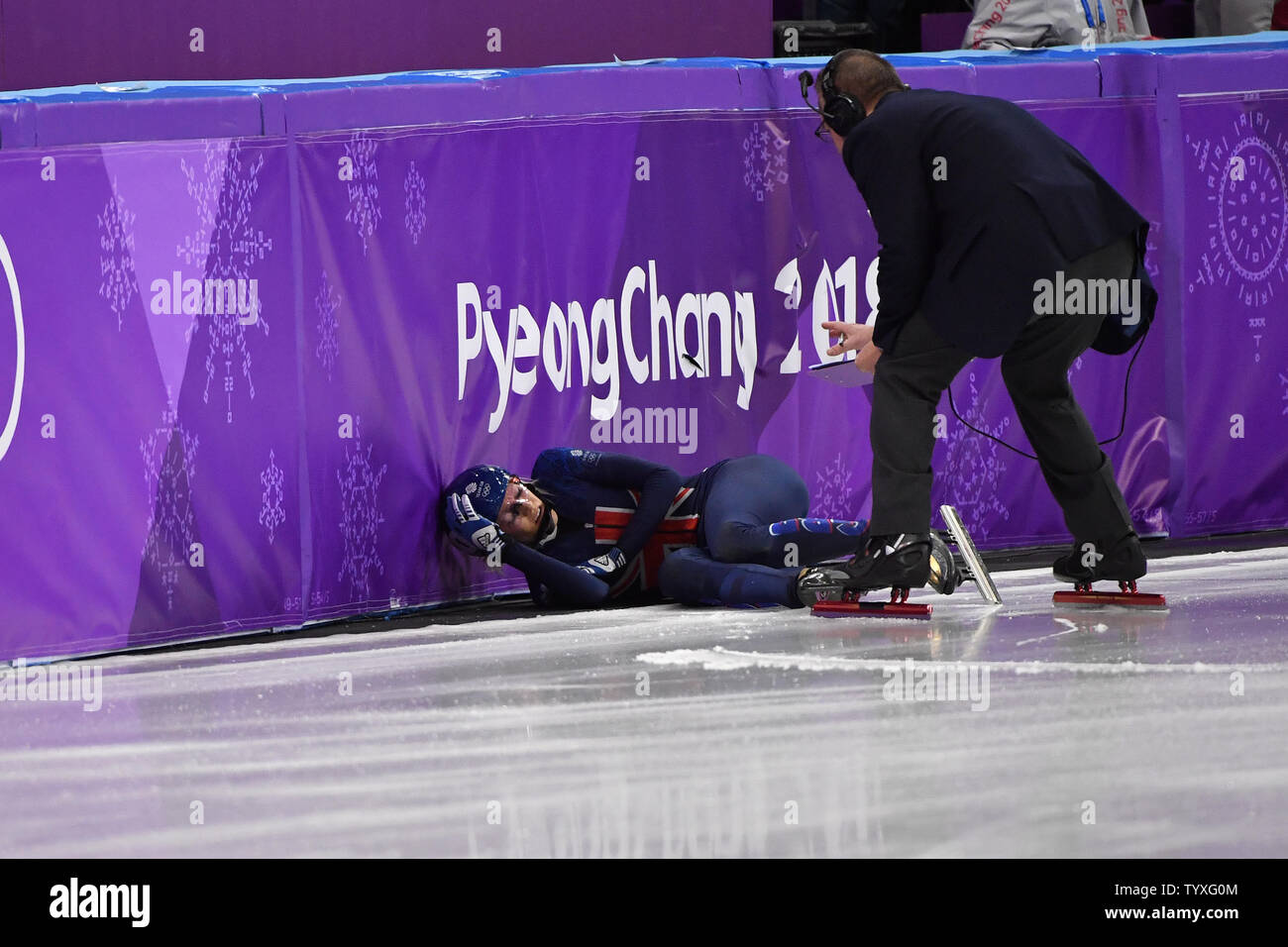 Via funzionari eseguire per controllare numero uno al mondo Elise Christie della Gran Bretagna dopo che aveva colpito il ghiaccio sulla curva finale dei quarti di finale nel Signore 1500m Short Track pattinaggio di velocità finale durante il Pyeongchang 2018 Olimpiadi invernali, a Gangneung Ice Arena in Gangneung, Corea del Sud, il 17 febbraio 2018. Foto di Richard Ellis/UPI Foto Stock