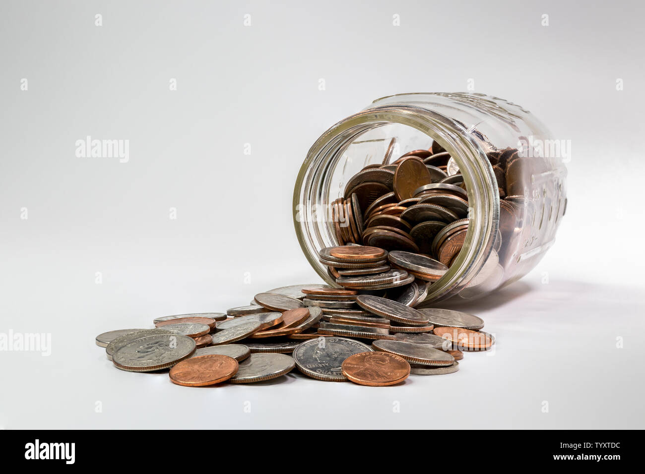 Cambiamento di ricambio jar posa sul suo lato con monete fuoriuscita Foto Stock